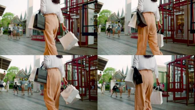 女人拿着购物袋走路
