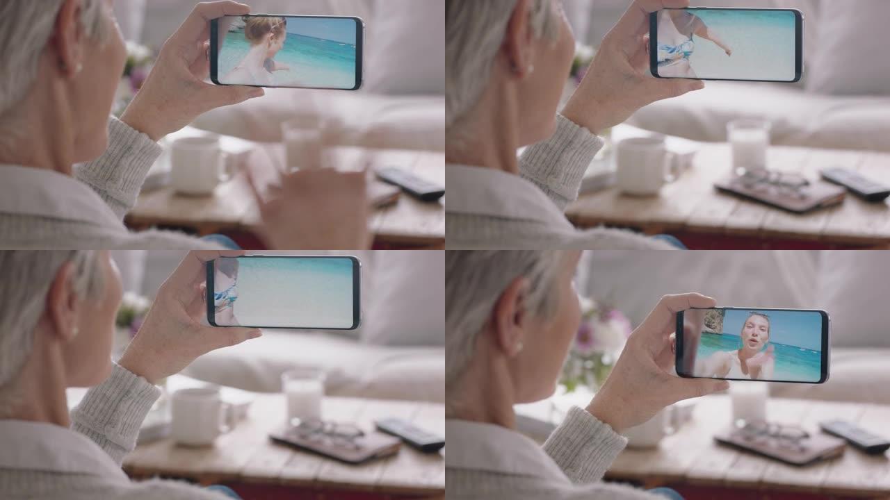 成熟的女人在意大利度假海滩上用智能手机向女儿挥手视频聊天，在手机上分享旅行体验，享受与祖母4k聊天的
