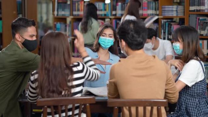 学生与新常态一起庆祝并在图书馆戴口罩