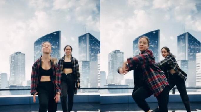 垂直屏幕: 两名时尚的年轻专业女舞者在大型Led墙壁屏幕前表演嘻哈舞蹈套路，现代城市天际线和工作室环