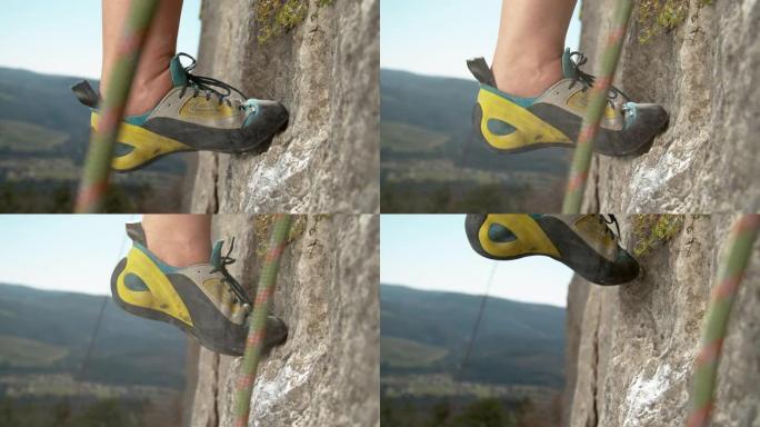 宏观: 女人攀岩爬上悬崖，在粉笔卷曲的抓地力旁边