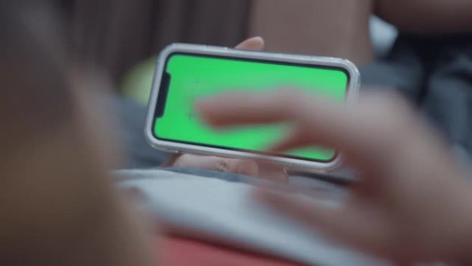 女人在家使用色度键绿屏智能手机