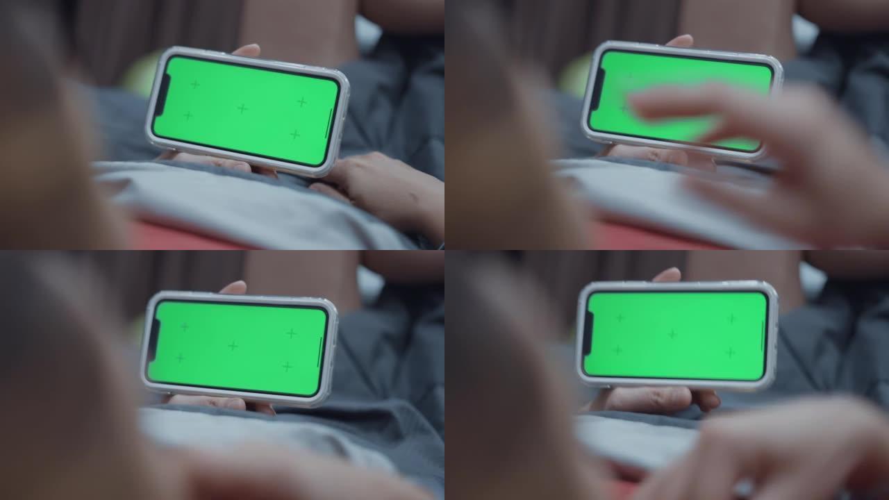女人在家使用色度键绿屏智能手机