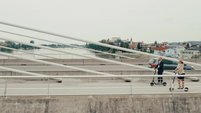 空中女商人和商人在桥上骑电动踏板车