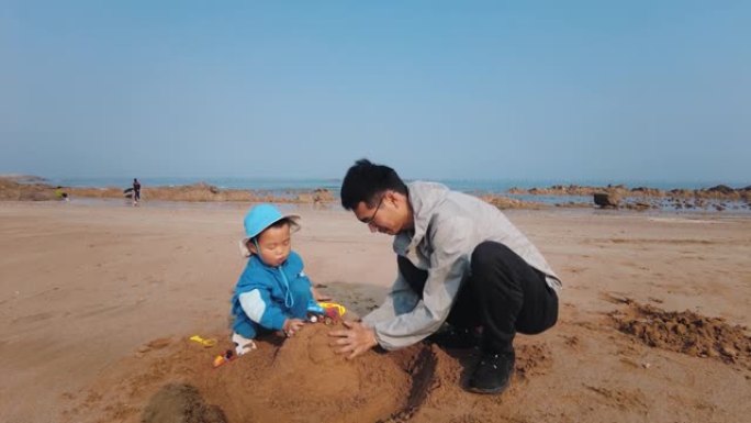 父亲和儿子在海滩上玩沙子