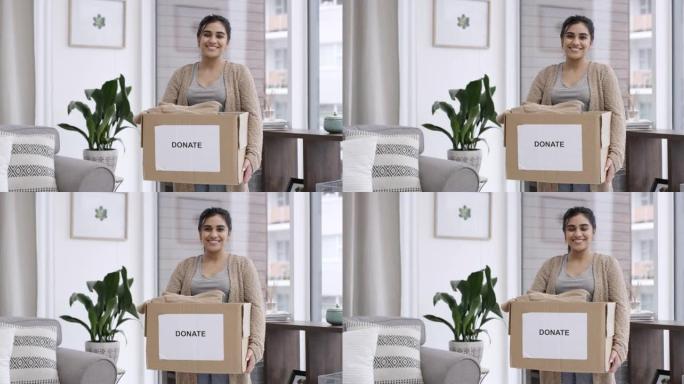 4k视频片段，一名妇女在家中拿着一盒带有 “捐赠” 字样的衣服