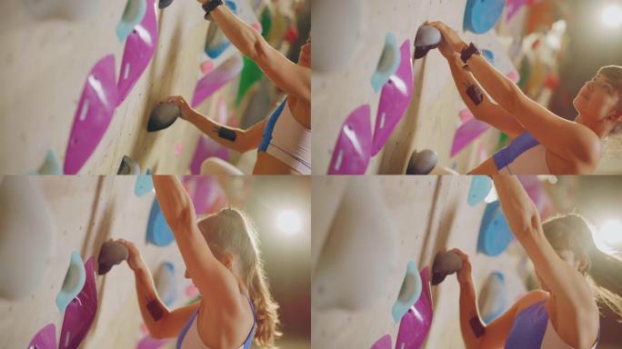 运动女攀岩者在健身房的抱石墙上练习单人攀岩。女性在室内健身设施锻炼，为健康的生活方式训练做极限运动。