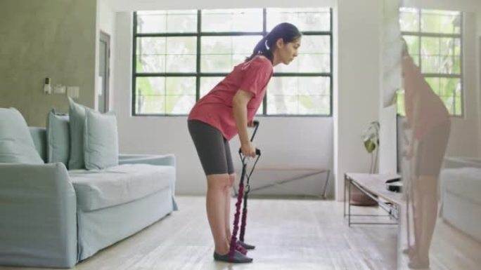 亚洲运动女子在家用阻力带锻炼