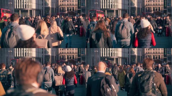 拥挤的通勤者在高峰时段在伦敦市中心区伦敦桥上行走的慢动作镜头