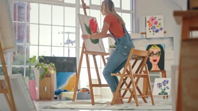 创造性的女艺术家在画布上用调色板和画笔绘画。画家在她的工作室里发展艺术技能。年轻女子在她的艺术工作室