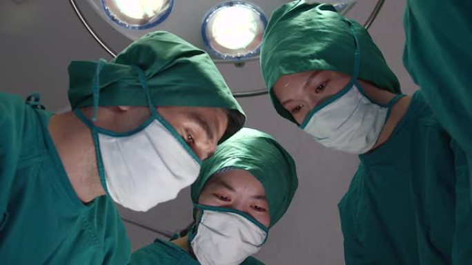 一群医生和护士正在帮助手术室的病人进行手术。