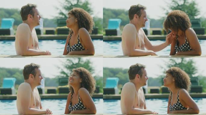 暑假成熟夫妇在室外游泳池边缘放松的侧视图 -- 慢动作拍摄