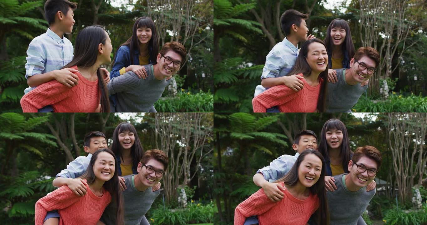 微笑的亚洲父母小猪在花园里支持快乐的儿子和女儿