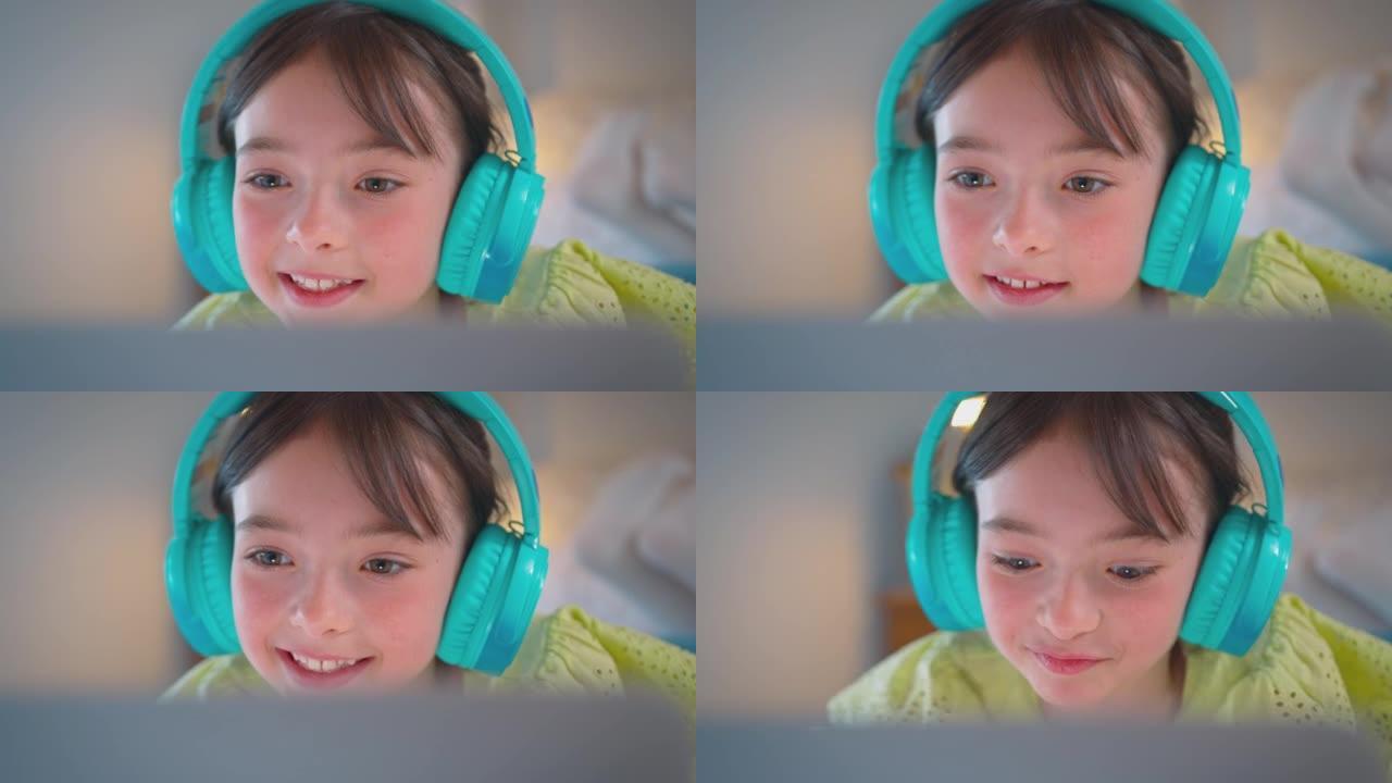 卧室里的女孩躺在床上，戴着无线耳机在笔记本电脑上听音乐或流媒体电影-慢动作拍摄