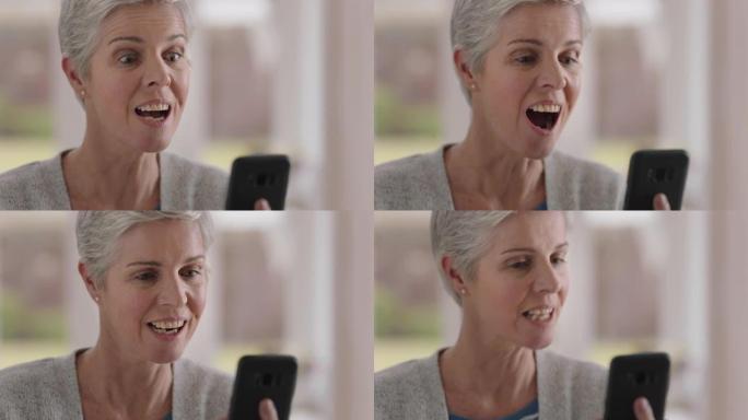 美丽的成熟女人使用智能手机进行视频聊天祖母享受对话看起来惊讶地分享生活方式在手机上聊天在家放松4k