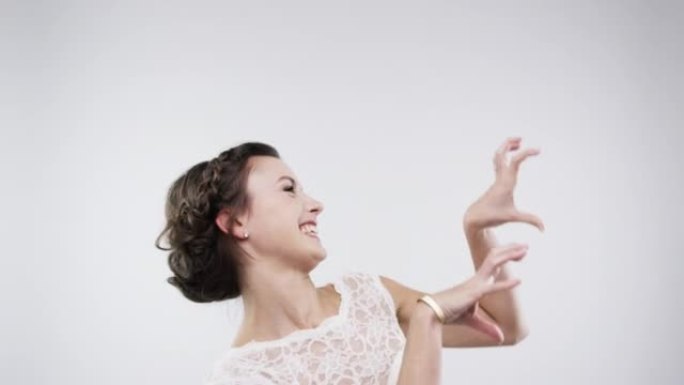 4k视频片段，一个美丽的年轻新娘在工作室背景下跳舞