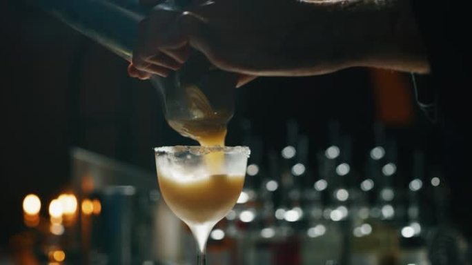 专业调酒师的特写镜头正在酒吧或迪斯科俱乐部为顾客准备精英酒鬼。