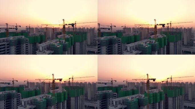 日落时建筑工地起重机的鸟瞰图