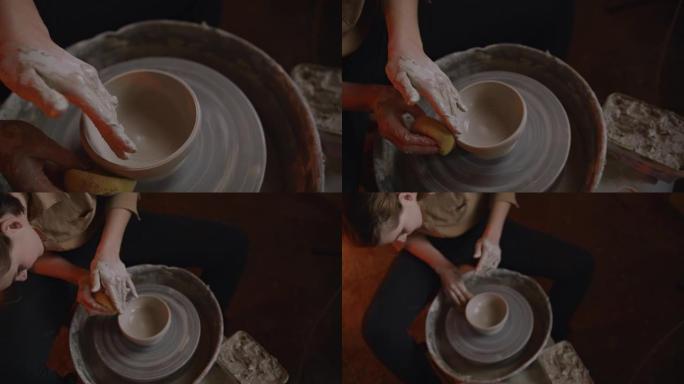SLO MO专业女陶工在陶艺工作室中塑粘土。慢动作拍摄的一名年轻女子在温暖的灯光照亮的陶器工作室里模