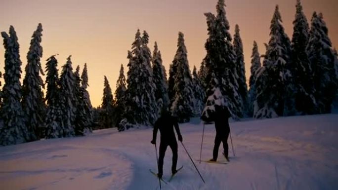 SLO MO两名无法识别的越野滑雪者在日落时滑雪