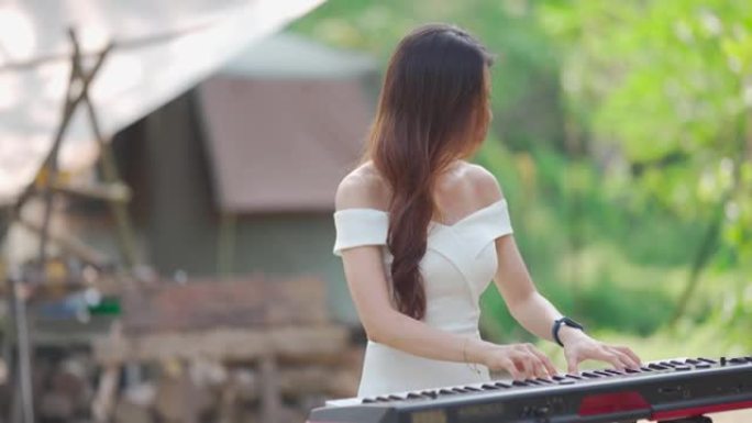 亚洲华裔女键盘手在农村地区弹奏电钢琴