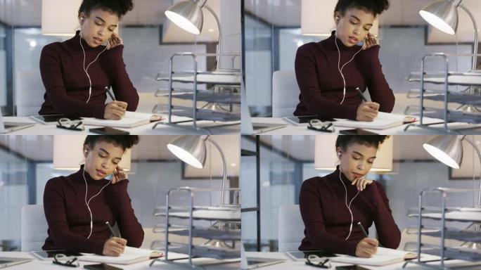 一个年轻的女商人在笔记本上写字并在现代办公室使用耳机的4k视频片段