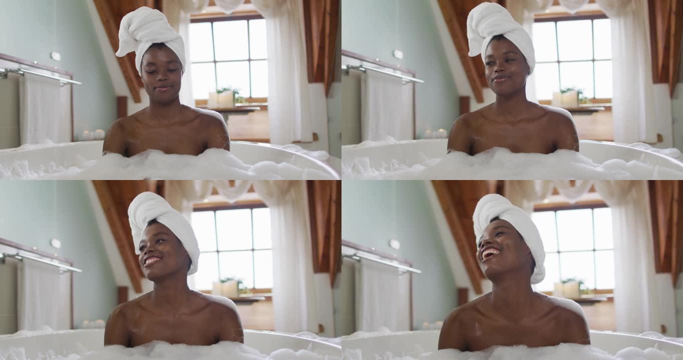 快乐的非洲裔美国迷人的女人在浴室的泡沫浴缸中放松