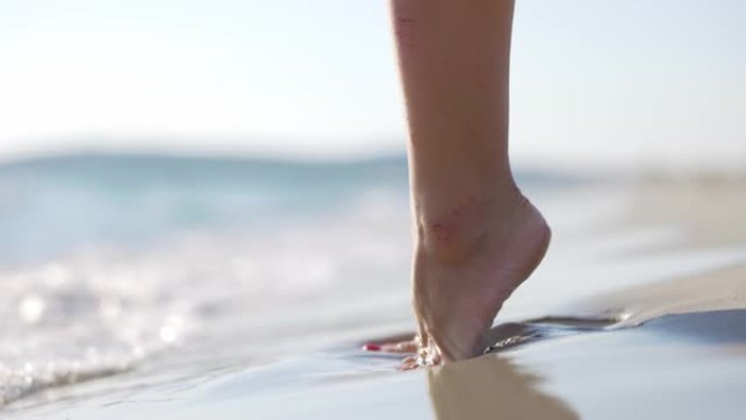 意大利海滩上女人脚的慢动作视图。