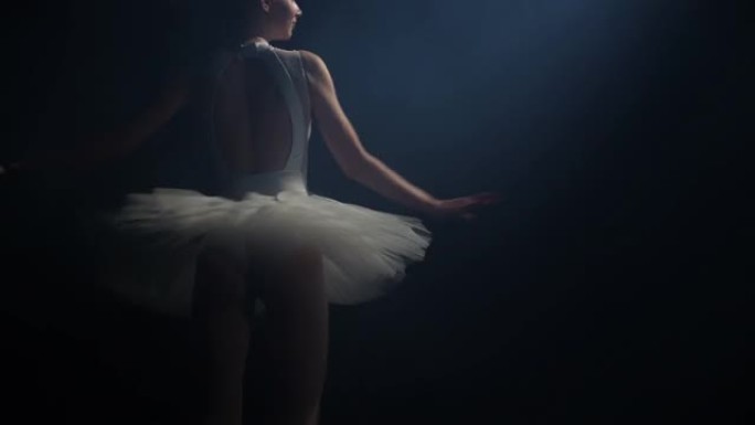 年轻的芭蕾舞女舞者在工作室的黑暗中旋转