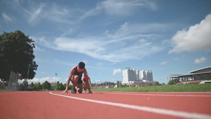 空气动力学亚洲中国女男运动员在跑道上冲刺，并在田径场上冲向终点线