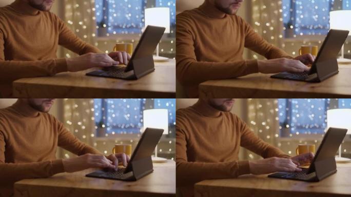一名穿着针织毛衣的男子在数字平板电脑上工作