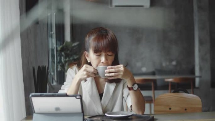 年轻女子在咖啡馆使用数字平板电脑。