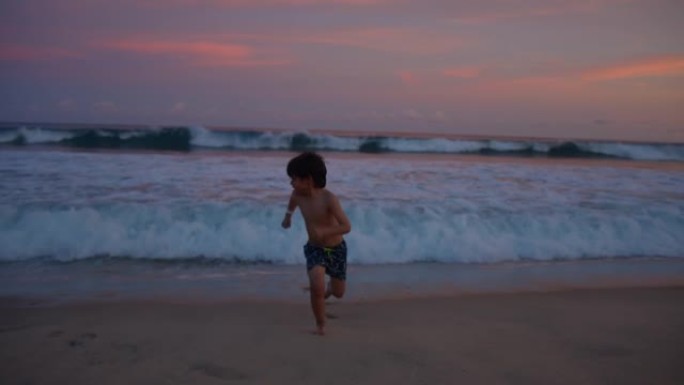 顽皮的小男孩在海滩上奔跑并拍打海浪
