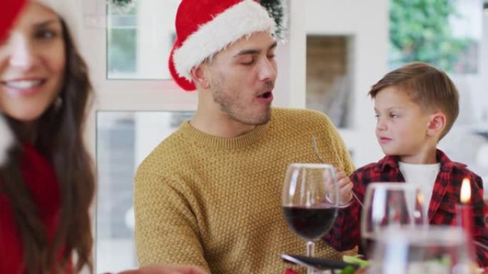 高加索人的儿子在圣诞节用餐时用叉子给父亲食物