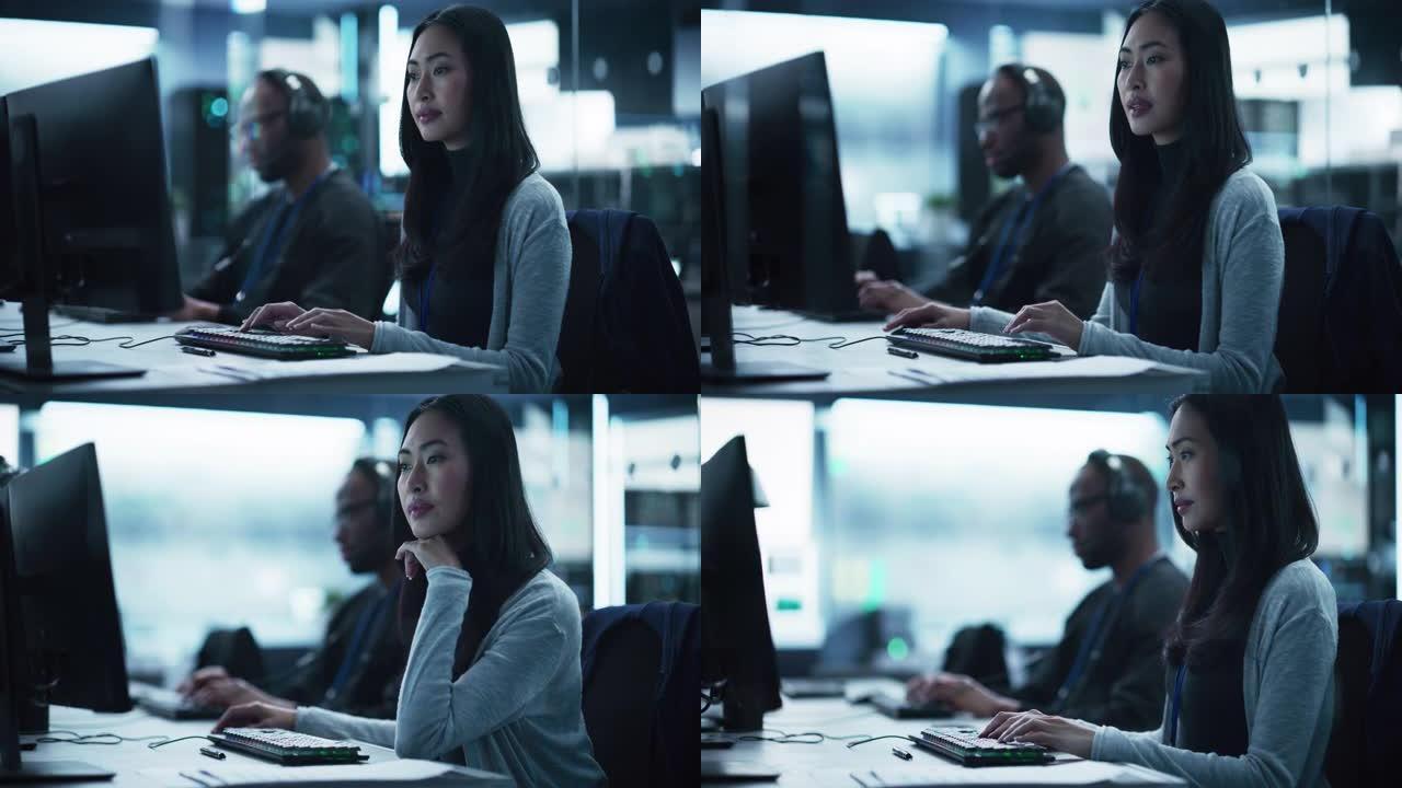 一位有思想的亚洲工程师在技术公司实验室从事计算机工作的肖像。年轻女子为创新的互联网和软件服务项目编写