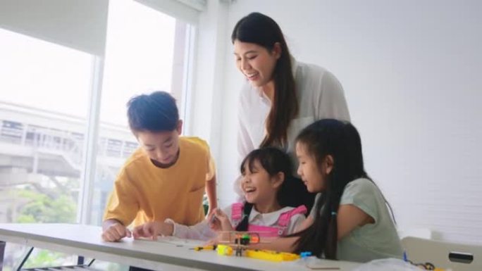 老师教小学生学习机器人编程和算法思维培训班。小学教育STEM教育概念。