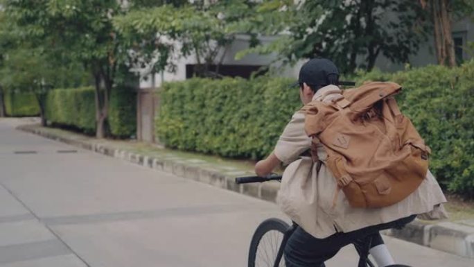 手臂残疾的英俊男子在城市街道上骑自行车。