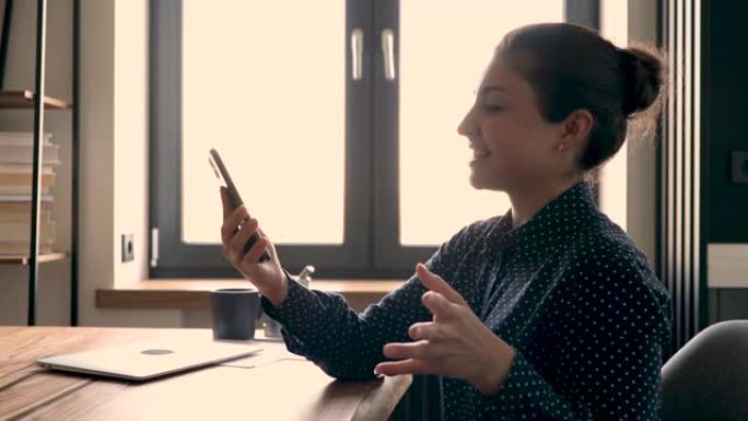 印度女商人拿着手机使用视频电话应用程序与客户交谈