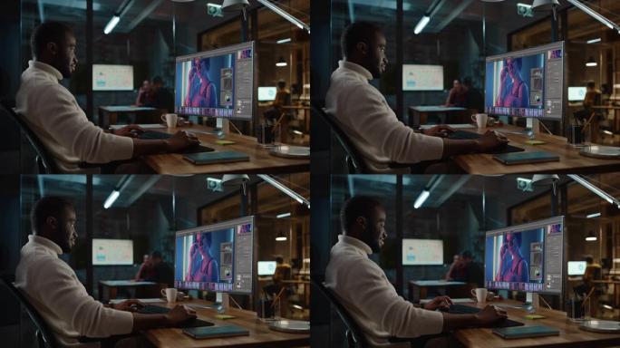 英俊的黑人非洲裔美国专家在创意办公环境中从事台式电脑工作。Hipster Male正在数字图形编辑软