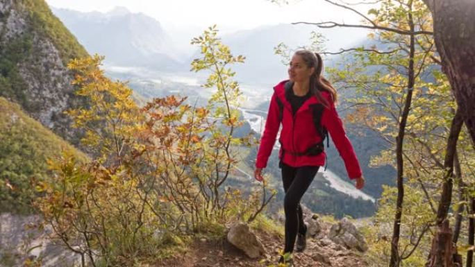 女徒步旅行者在风景令人难以置信的群山中上山行走