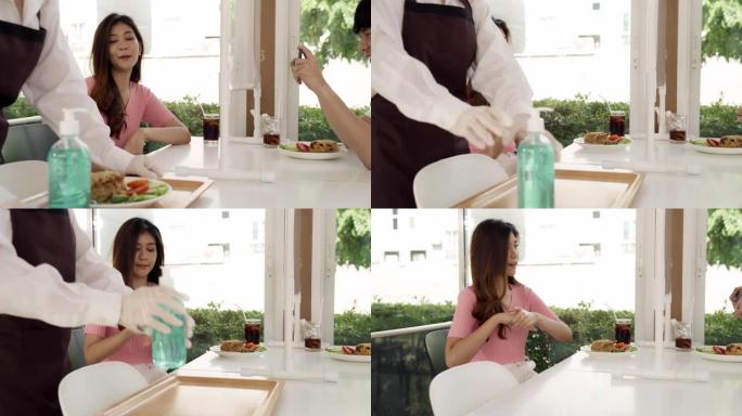 4K UHD多莉拍摄: 亚洲迷人的女服务员在用餐前向顾客推销酒精凝胶洗手液，以减少冠状病毒新型冠状病