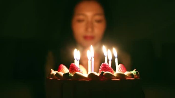 年轻女性在生日时用蛋糕祝福