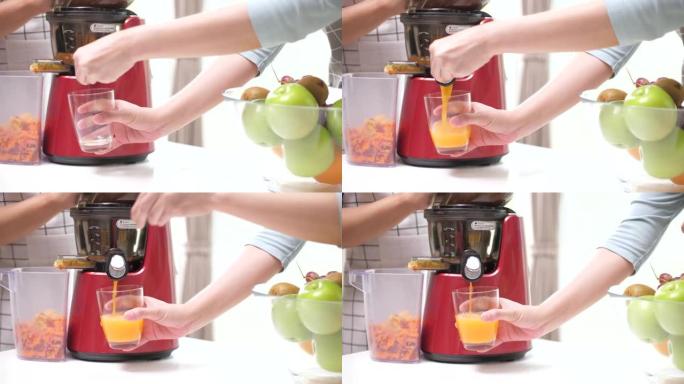 冷榨果汁与苹果橙和胡萝卜在冷榨机中混合