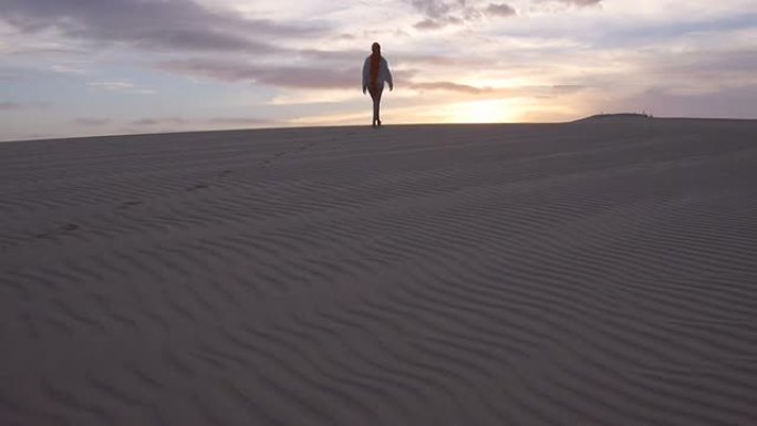 空中: 女性在日出时穿越沙漠
