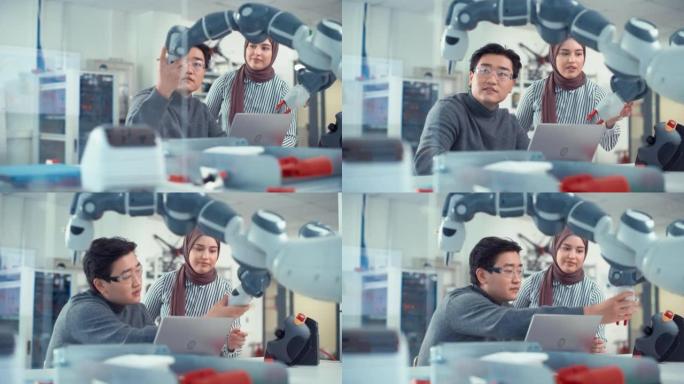 亚洲工程师与机器人开发实验室的中东女同事重新定位和检查机械臂。机器人机构的设计、操作和性能研究
