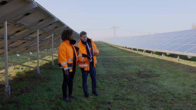 两名在太阳能电池板农场工作的维护工程师