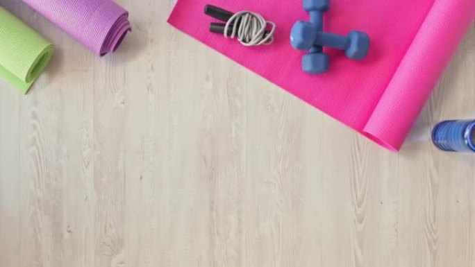 瑜伽垫和健身器材的上方视图。哑铃，跳绳和健身垫上的健身器材，在空的工作室里放复制空间。保持健康，在常