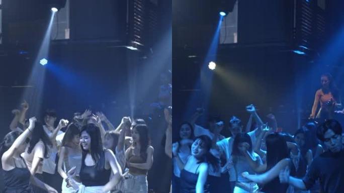 垂直视频，人们在聚会期间在俱乐部跳舞和欢呼，慢动作