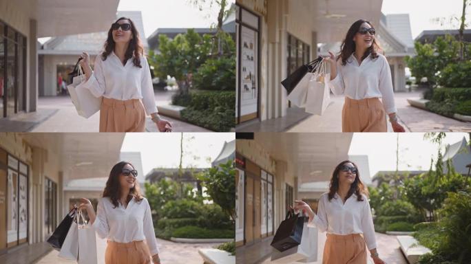 亚洲女性购物者带着购物袋散步