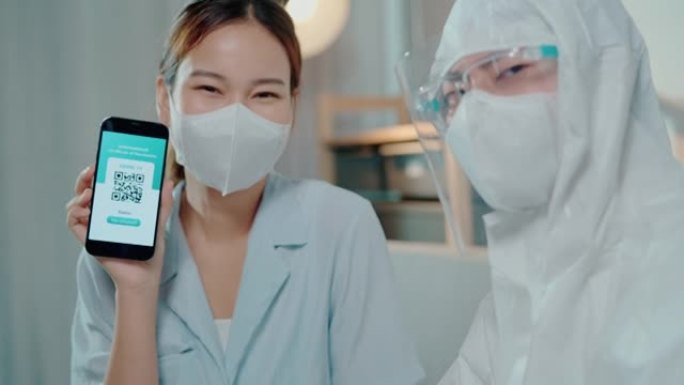 一名医生回家接种疫苗，一名年轻的亚洲妇女在她的新普通智能手机上展示了她的新型冠状病毒肺炎数字疫苗护照